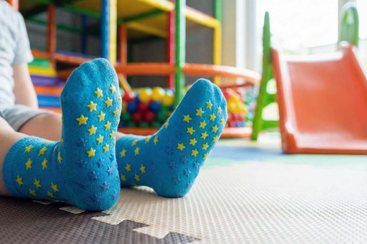 Kind mit Stoppersocken in einem Indoorspielplatz bei einem Kindergeburtstag